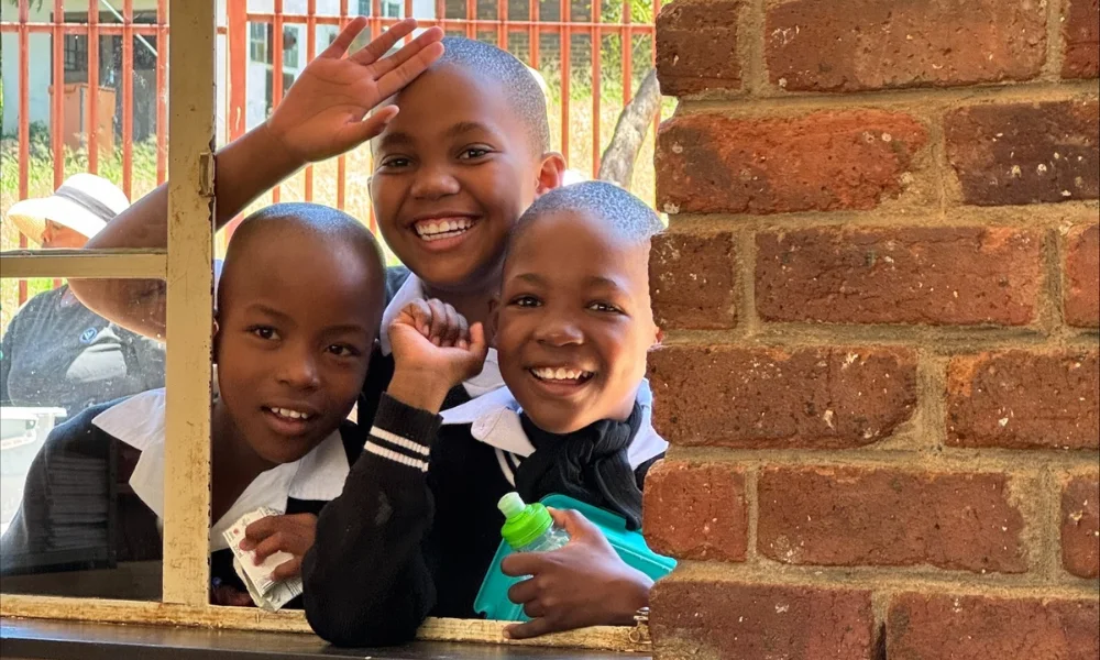 3 students waving through the window at Subiaco Primary