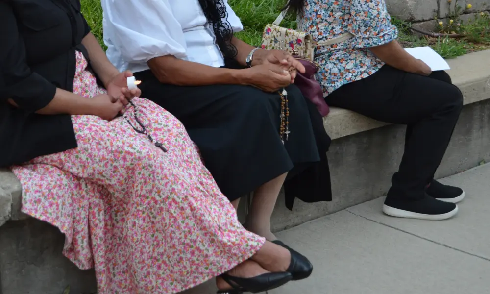 3 women praying with rosaries at the June 9th prayer vigil