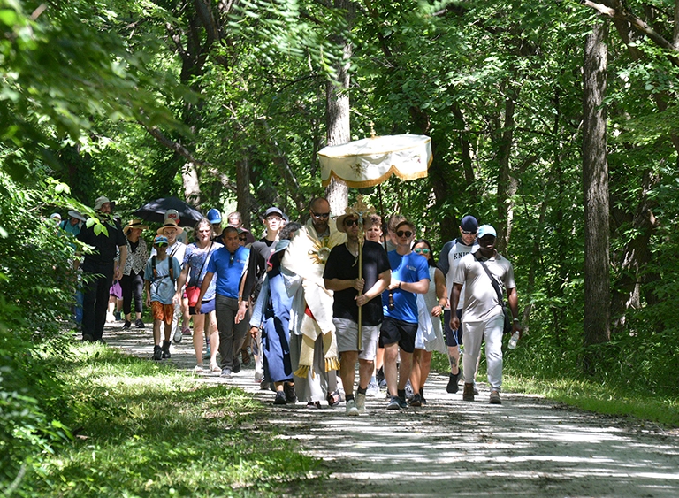 Pilgrims carry the Blessed Sacrament on a trail from Council Bluffs to Glenwood.