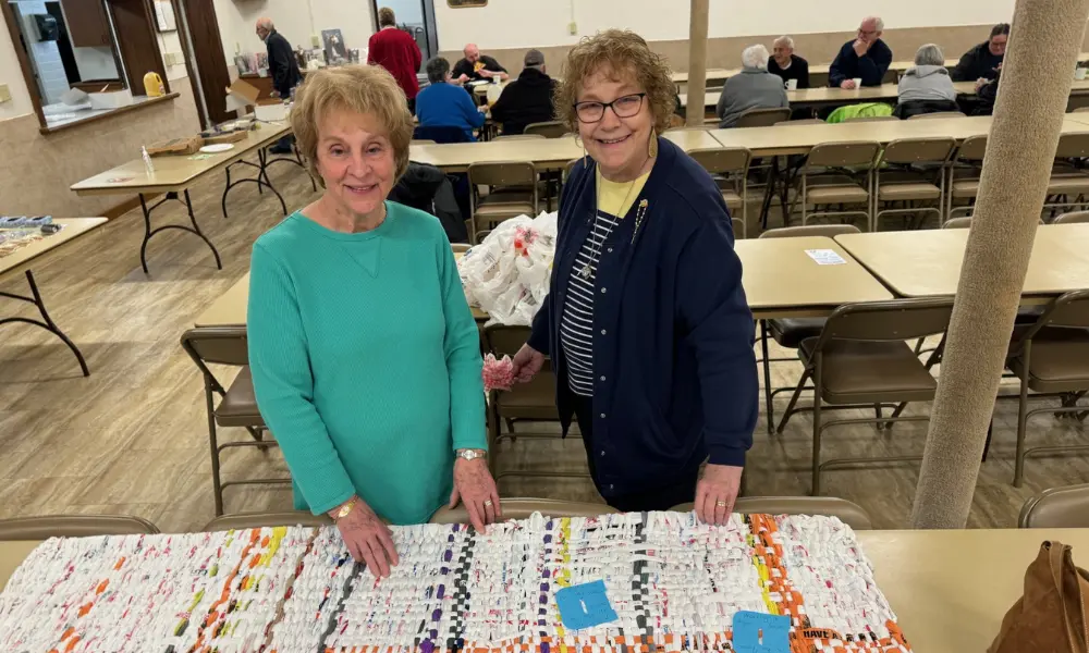 Parishioners stand next to finished plastic mat